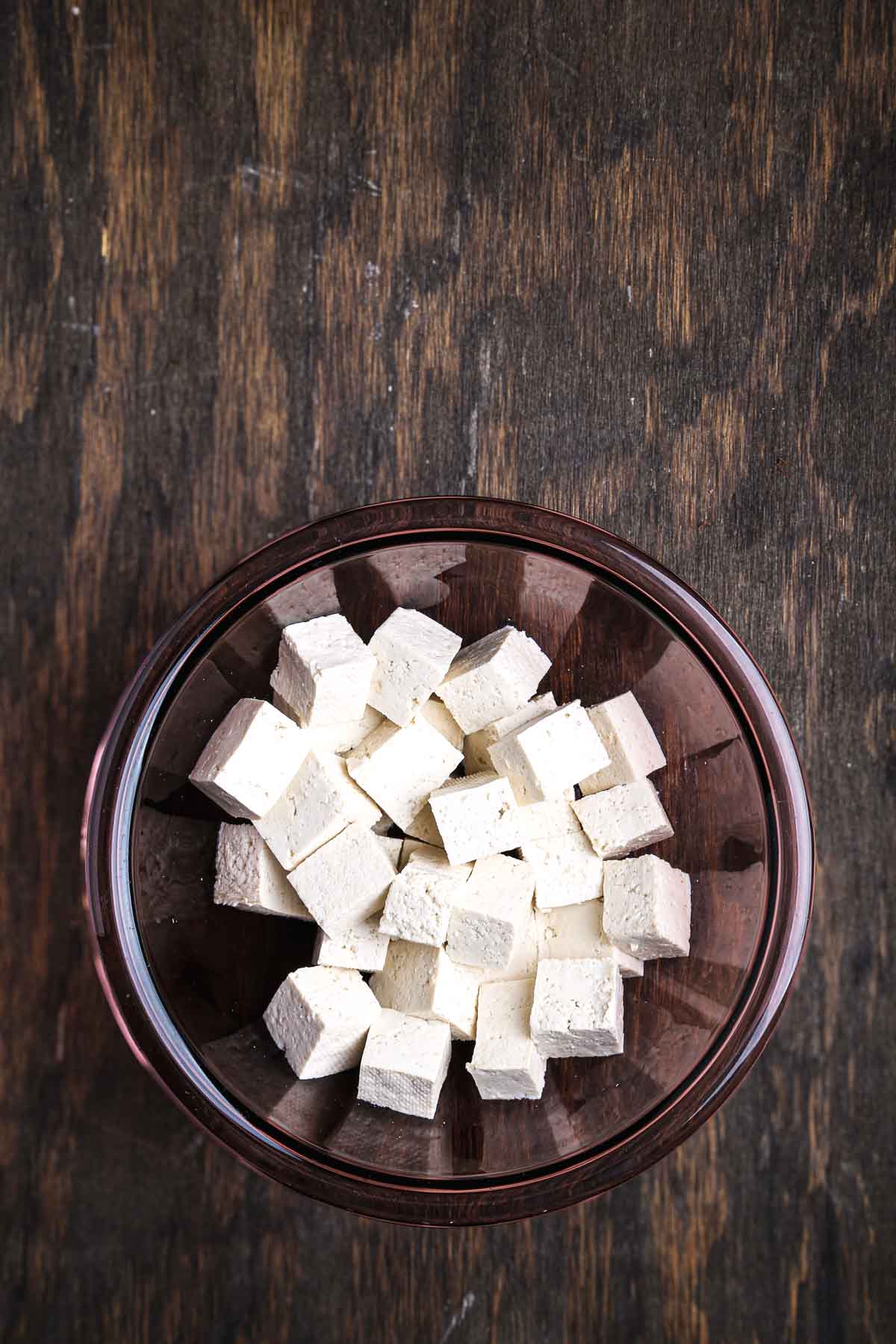 Cubes of firm tofu in a bowl, ready for coating.
