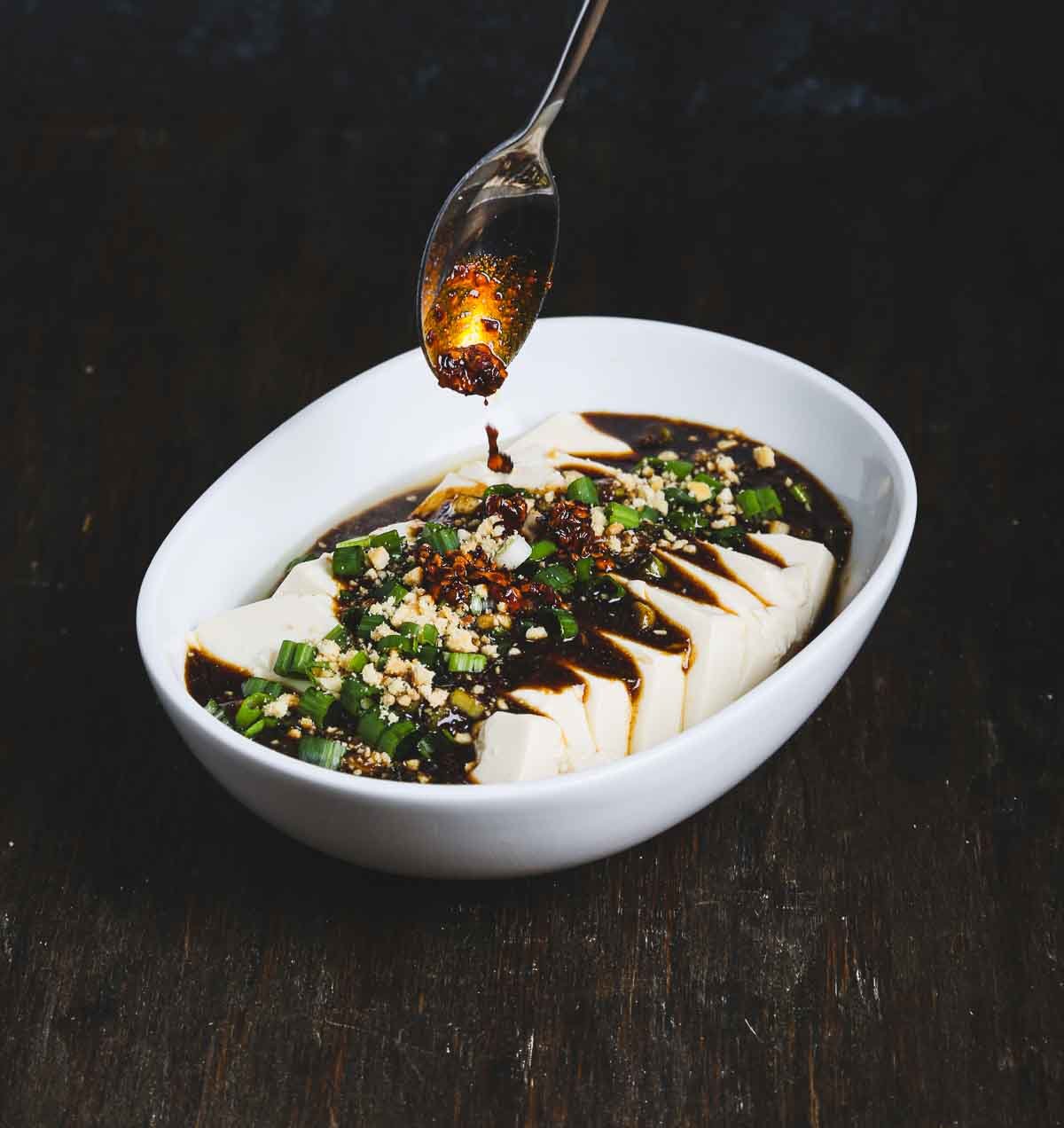Steamed tofu topped with fermented black bean sauce, scallions, and chili crisp.