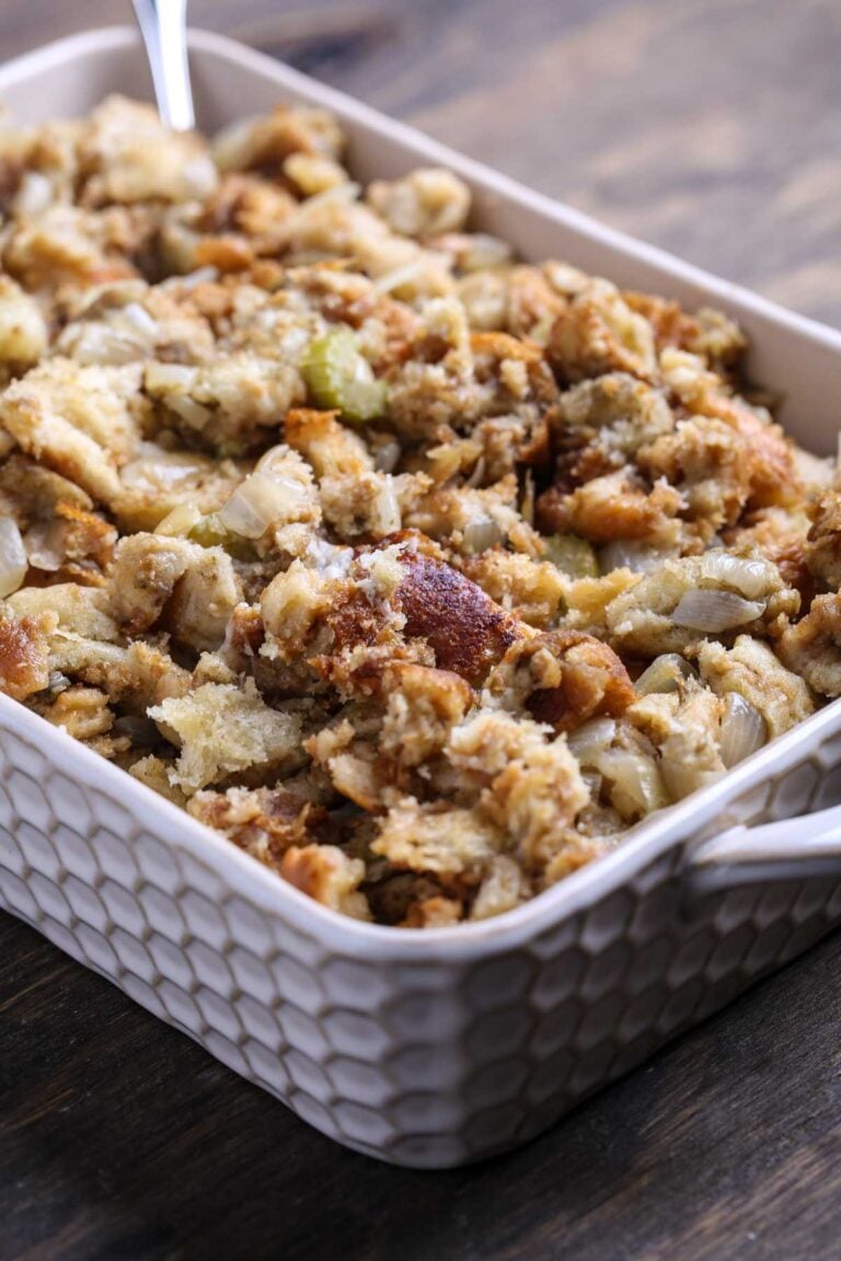 Angled view of vegan crockpot stuffing with a soft, sage-seasoned texture in a casserole dish.