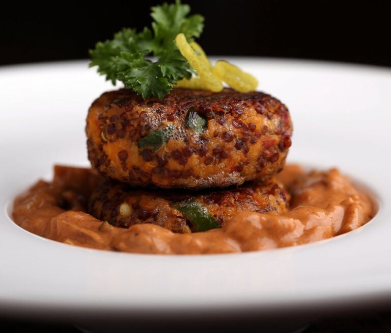 Sweet potato croquettes plated with sauce.