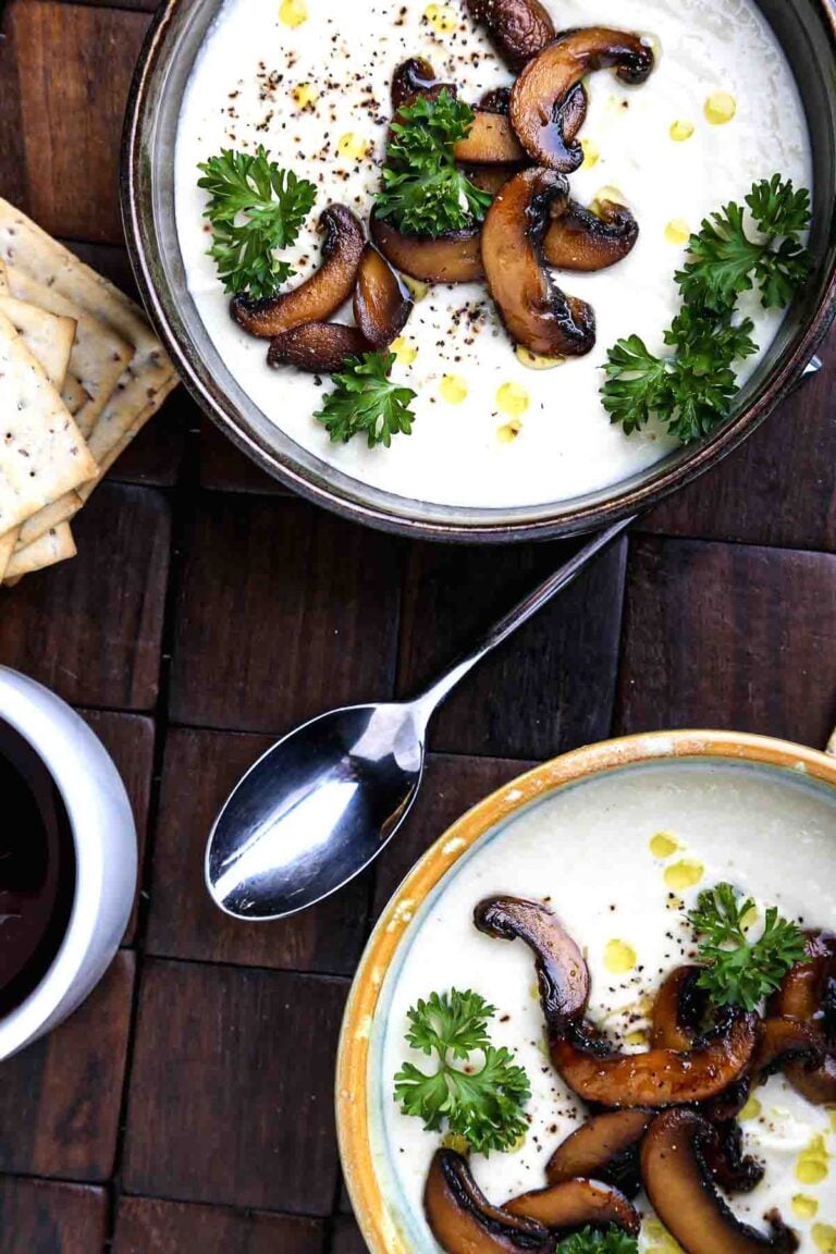 Creamy cauliflower soup topped with sautéed mushrooms, olive oil, and fresh parsley.