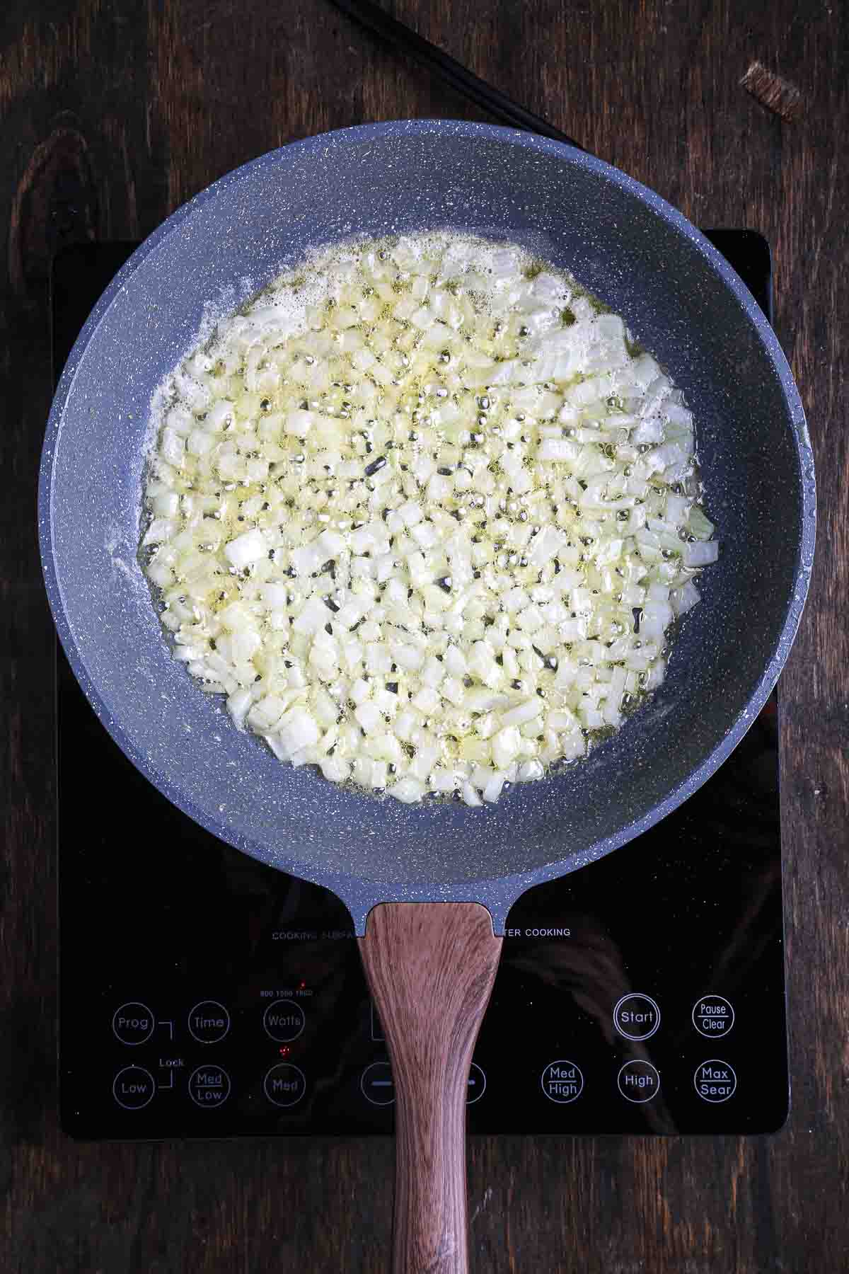 Chopped onion cooking in vegan butter until soft and lightly golden.