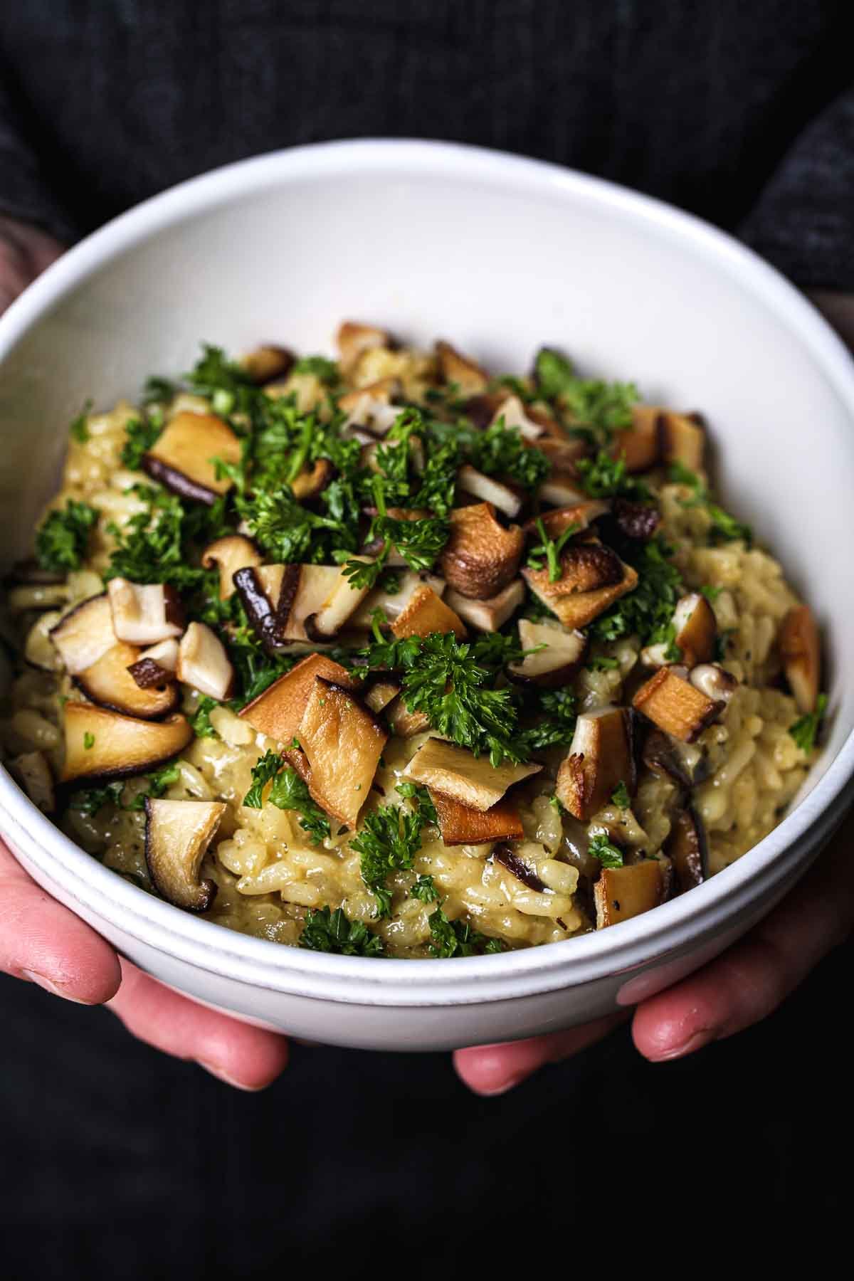 Vegan mushroom risotto served warm with caramelized mushrooms and chopped parsley.
