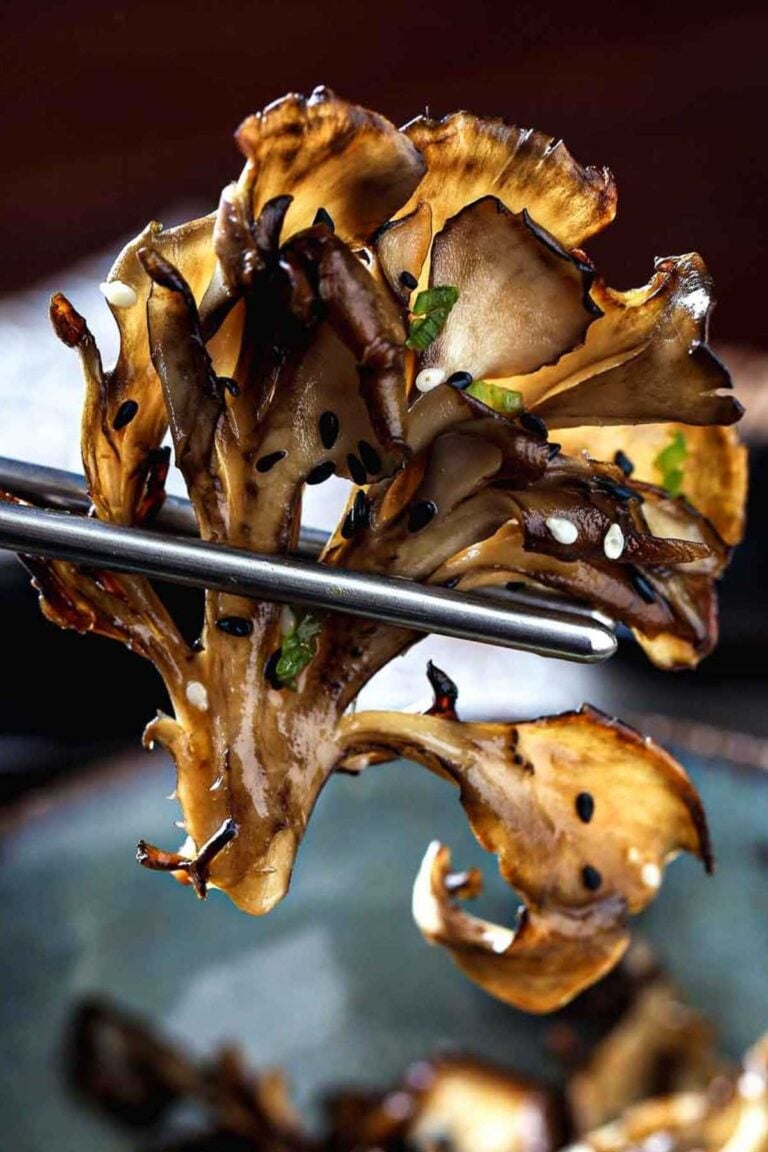 A cooked maitake mushroom with chopsticks.