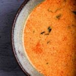 A bowl of vegan red curry sauce made with coconut milk, ginger, and basil.