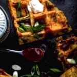 Crispy loaded hash brown waffles with melted vegan cheese, scallions, and sour cream.