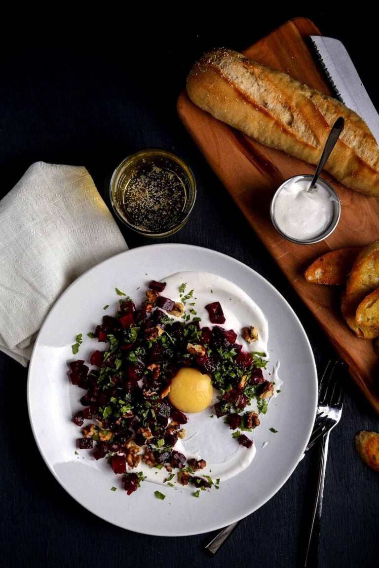 A plate of beet tartare with mango yolk and crostini.