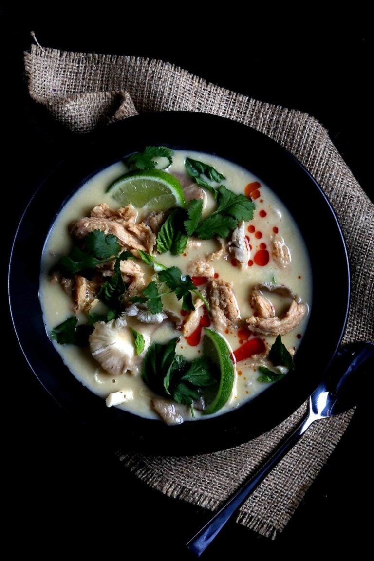 A bowl of tom kha soup with garnish.
