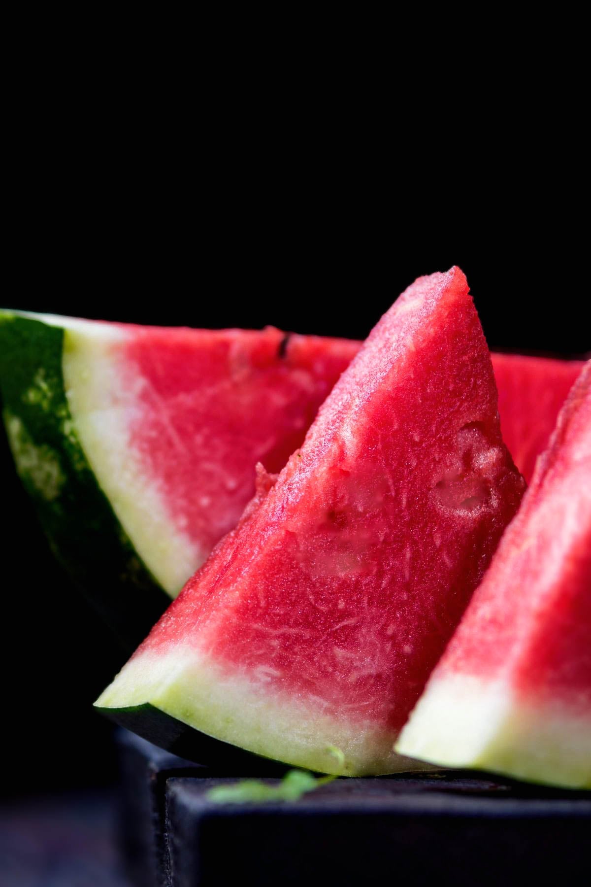 Slices of fresh watermelon on a tabletop.
