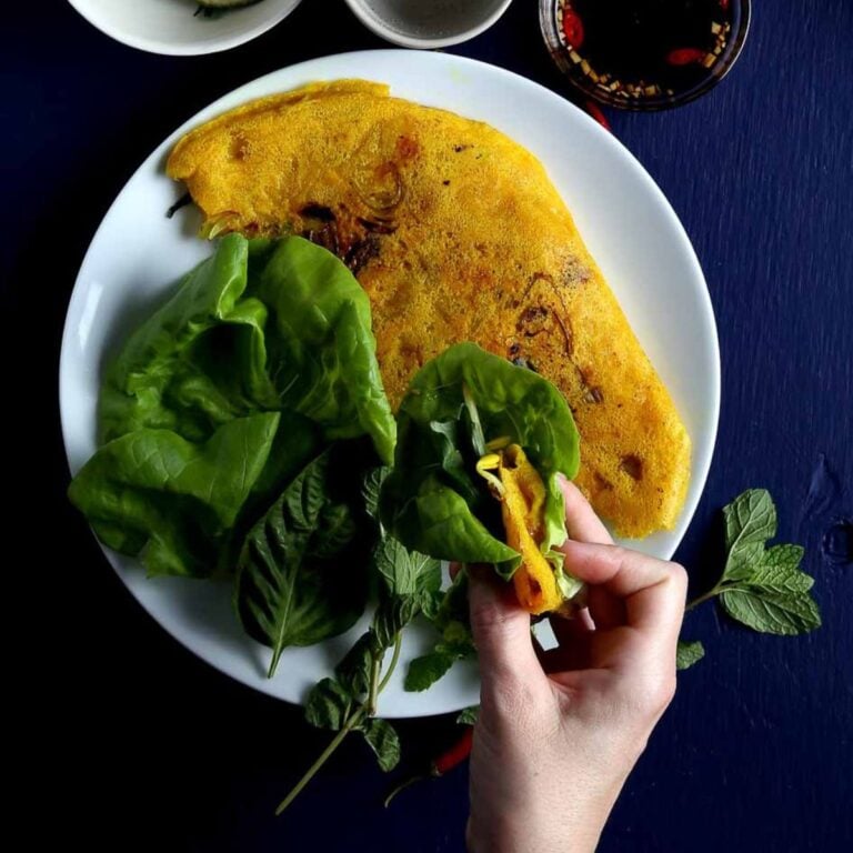 A piece of banh xeo wrapped in lettuce and herbs.
