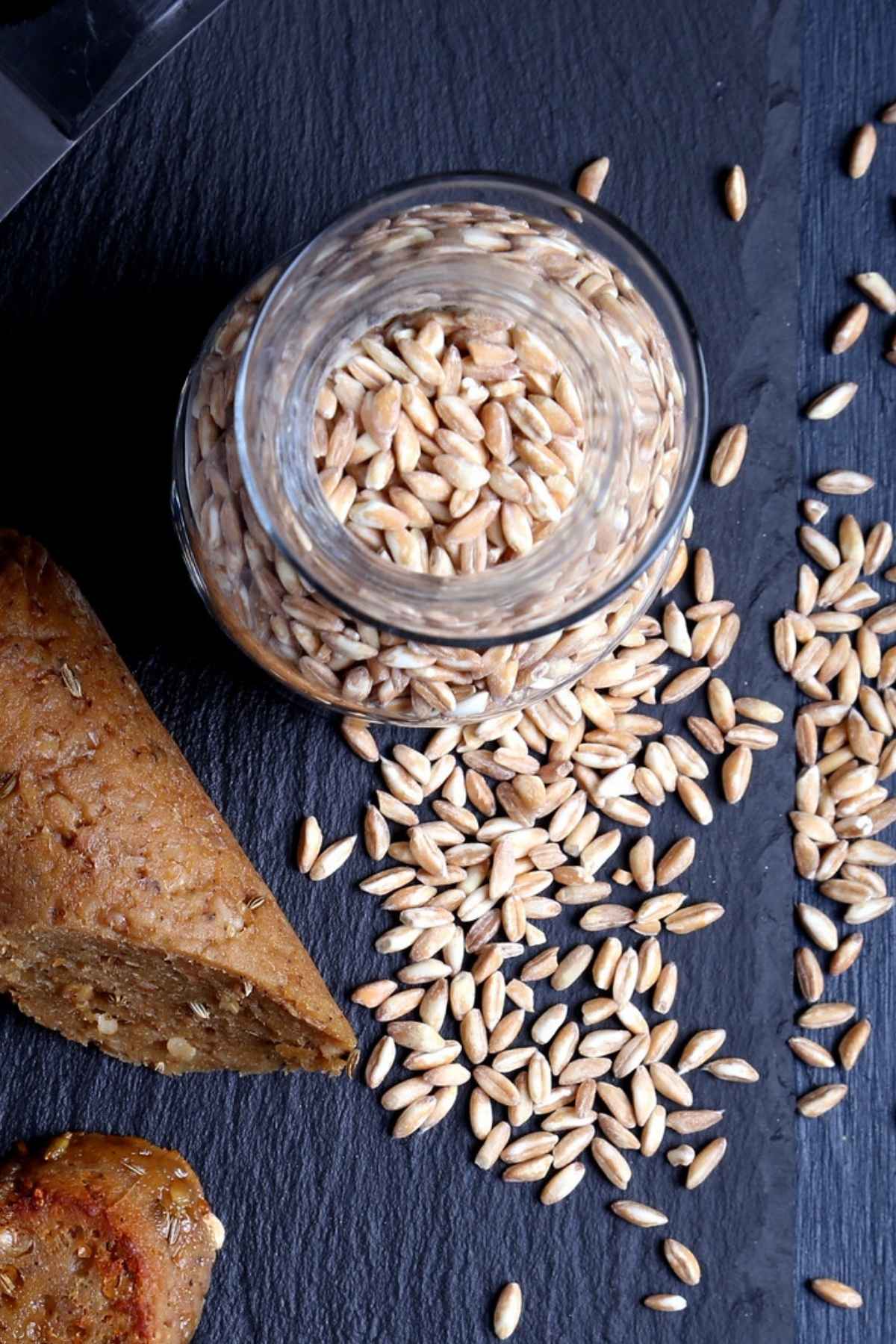 Farro grains beside sliced vegan Italian sausage showing the coarse grain texture in the seitan.