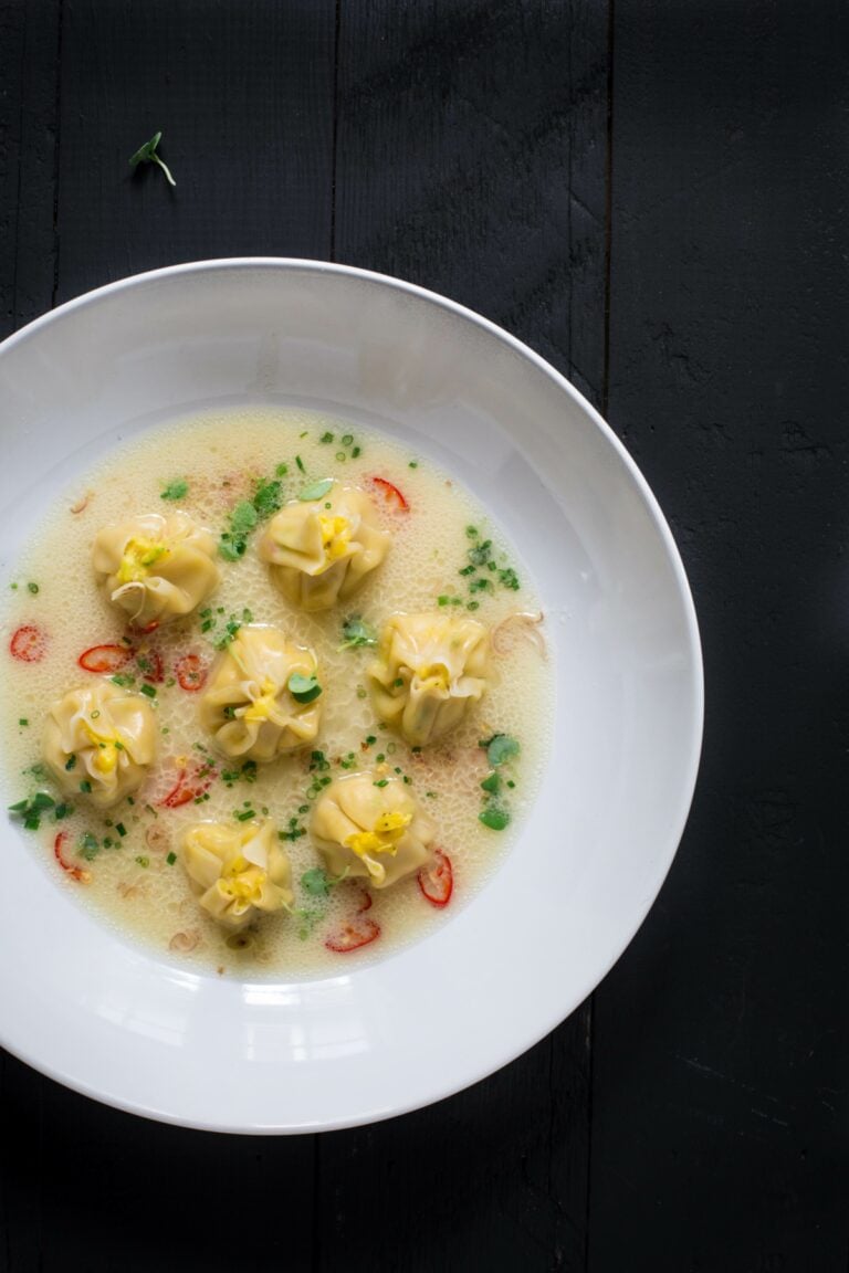 A bowl of corn dumplings in coconut corn broth.