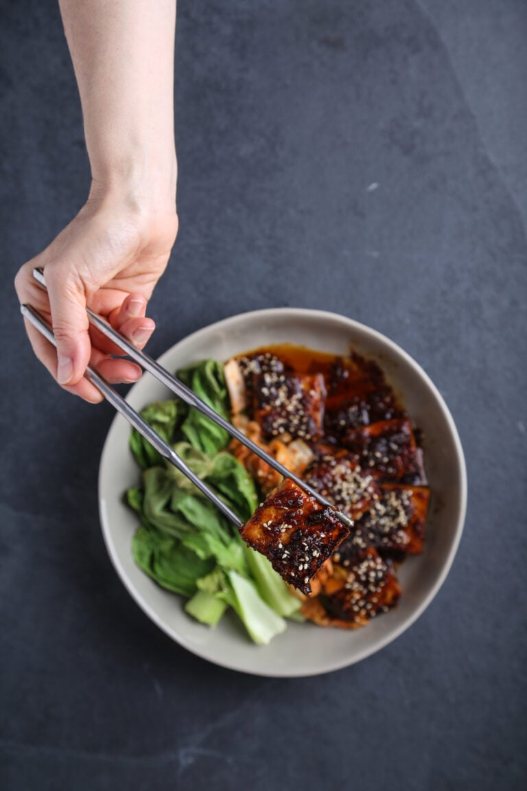 A bowl of spicy sambal tofu with wilted bok choy.