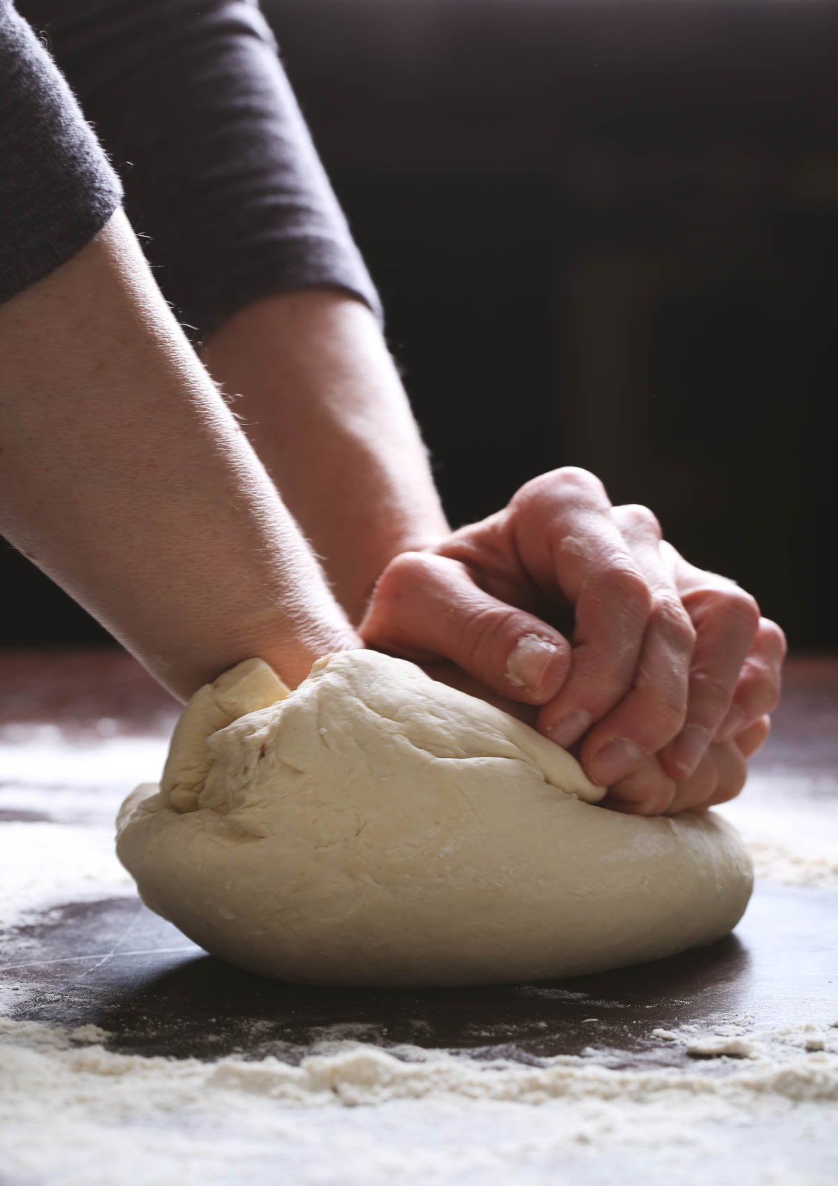 Close-up of kneading pizza dough until it becomes smooth and elastic.