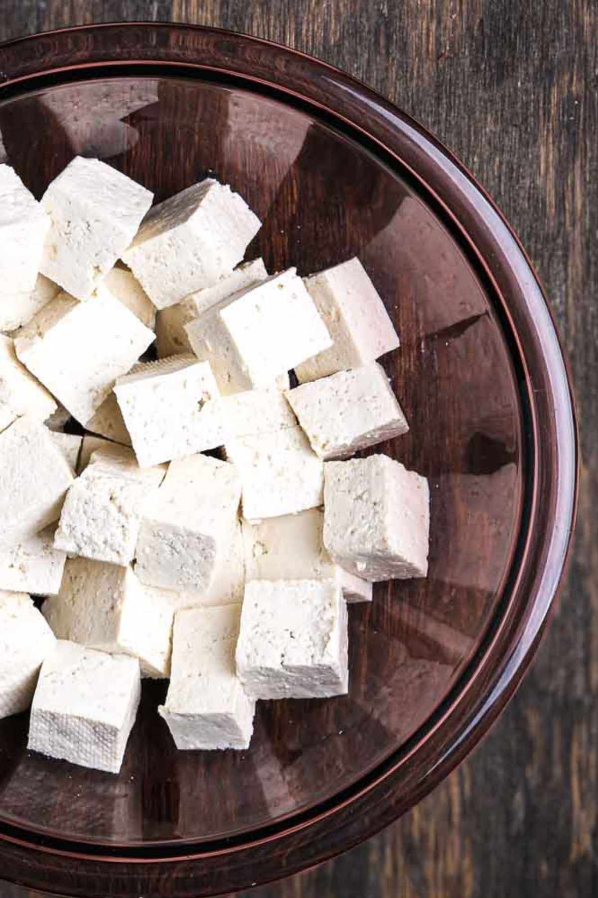 Cubed extra-firm tofu in a glass bowl.