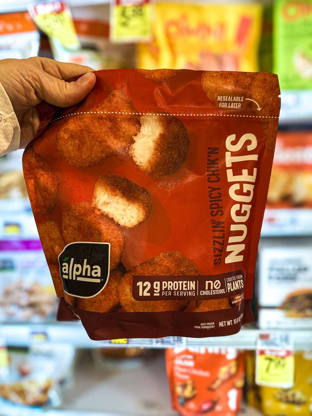 Alpha Sizzlin’ Spicy Chik’n Nuggets in a red resealable bag with plant-based protein label.