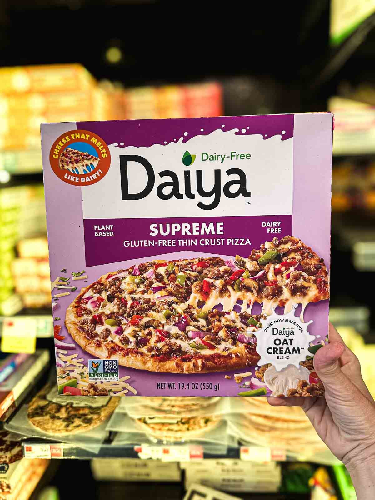 A box of Daiya Supreme Vegan Pizza, topped with sausage crumbles and oat-based cheese found in the vegan frozen foods section.