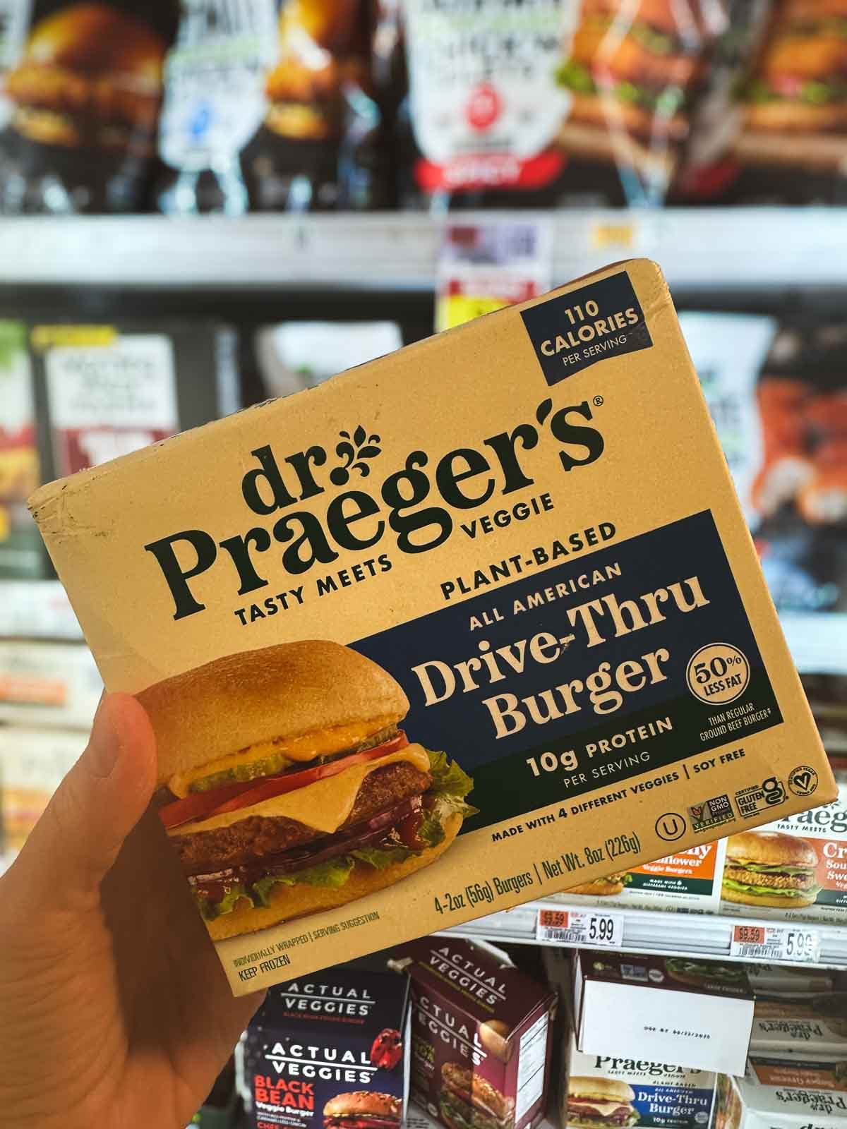 Dr. Praeger’s Drive-Thru Burger box featuring a veggie-packed patty with lettuce, tomato, and vegan cheese on a toasted bun.