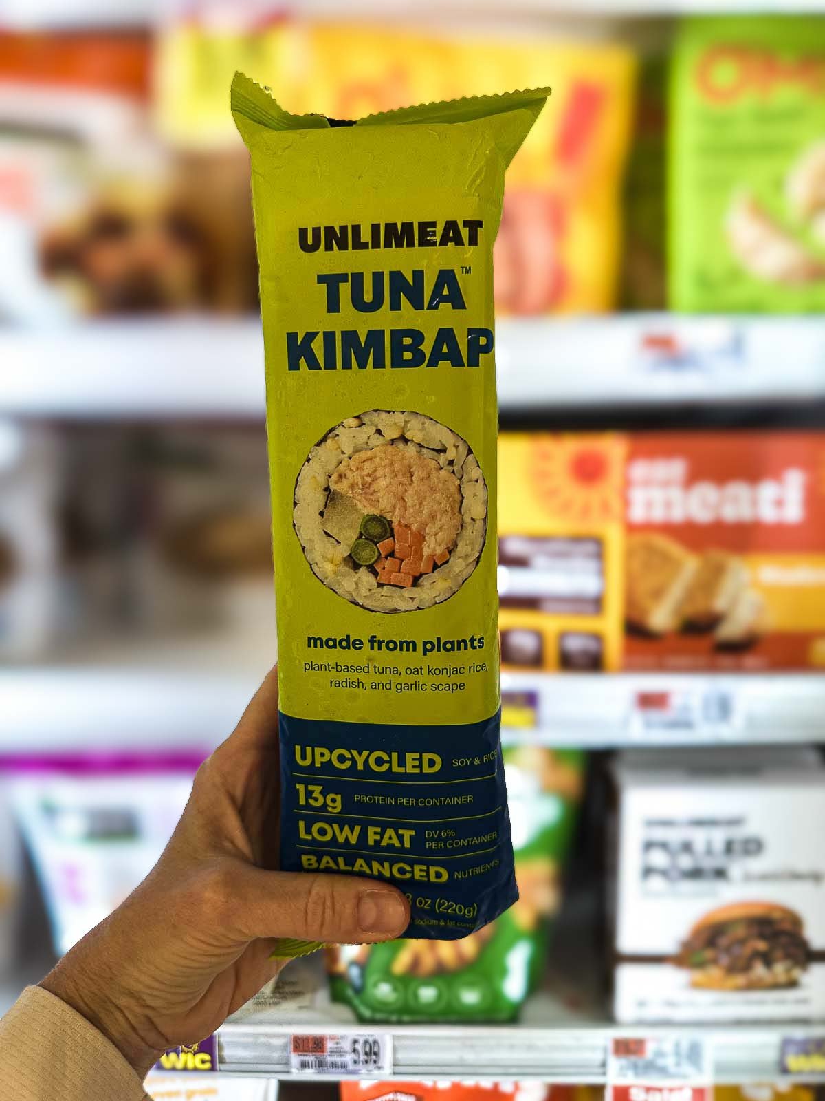 A frozen package of Unlimeat Vegan Tuna Kimbap with plant-based tuna and vegetables in a seaweed rice roll.