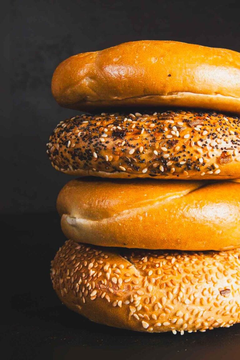 Stack of plain, sesame, and everything bagels showing classic vegan-friendly varieties.