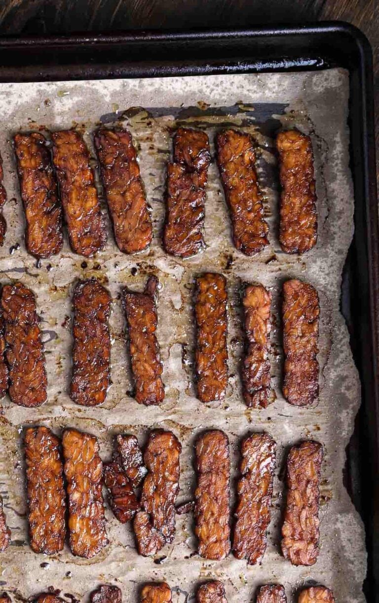 Close-up of crispy baked tempeh bacon with glossy, caramelized edges and smoky glaze.