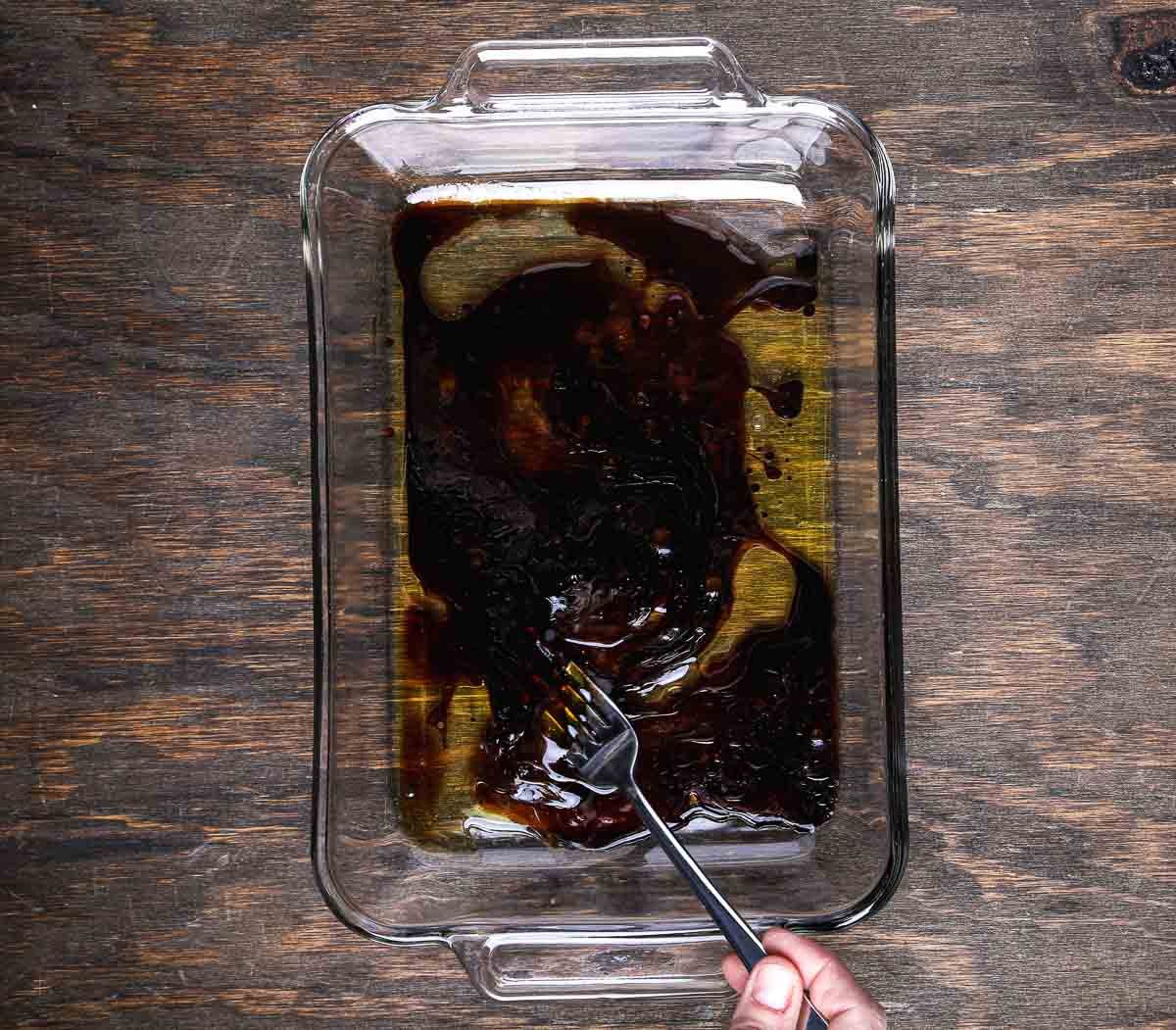 Mixing tamari, maple syrup, sesame oil, and liquid smoke for homemade tempeh bacon marinade.