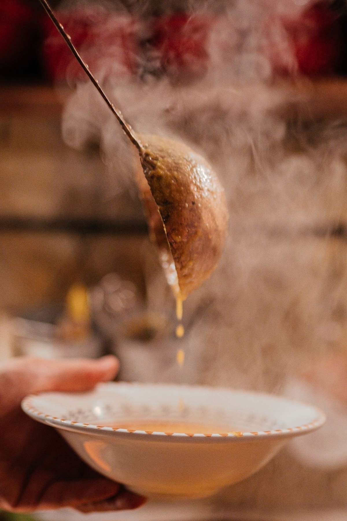 Steaming vegan soup ladled into a patterned bowl.