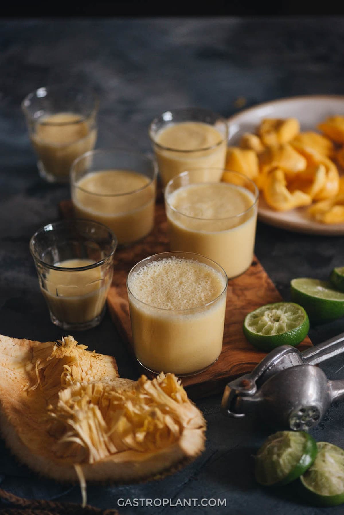Fresh jackfruit smoothie served in small glasses with lime, showcasing its creamy texture and tropical flavor.