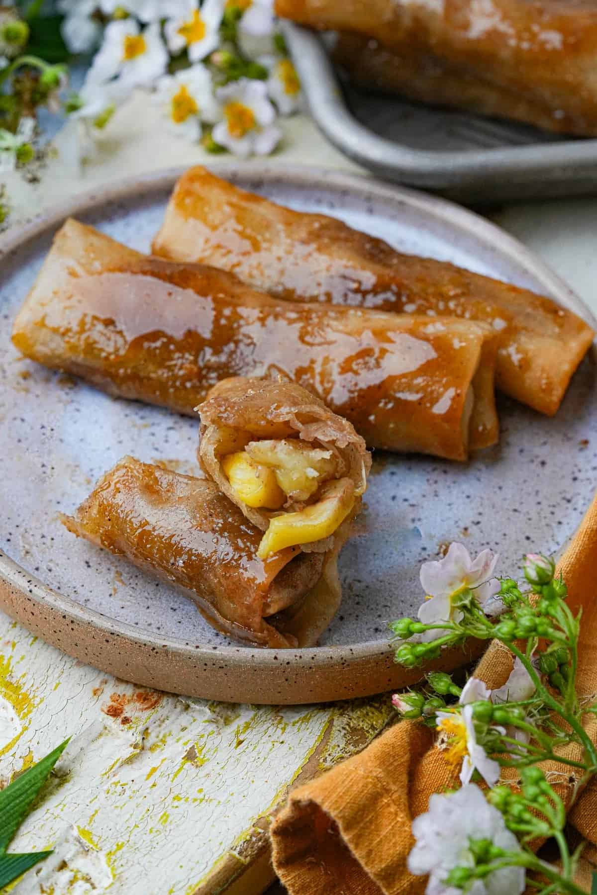 Filipino turon filled with ripe jackfruit and banana, fried until golden and glazed with caramelized sugar syrup.