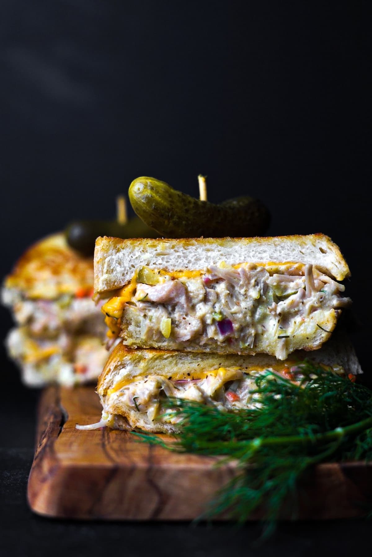 Vegan jackfruit tuna melt sandwich stacked with jackfruit, creamy plant-based melted cheese, and dill on toasted bread.