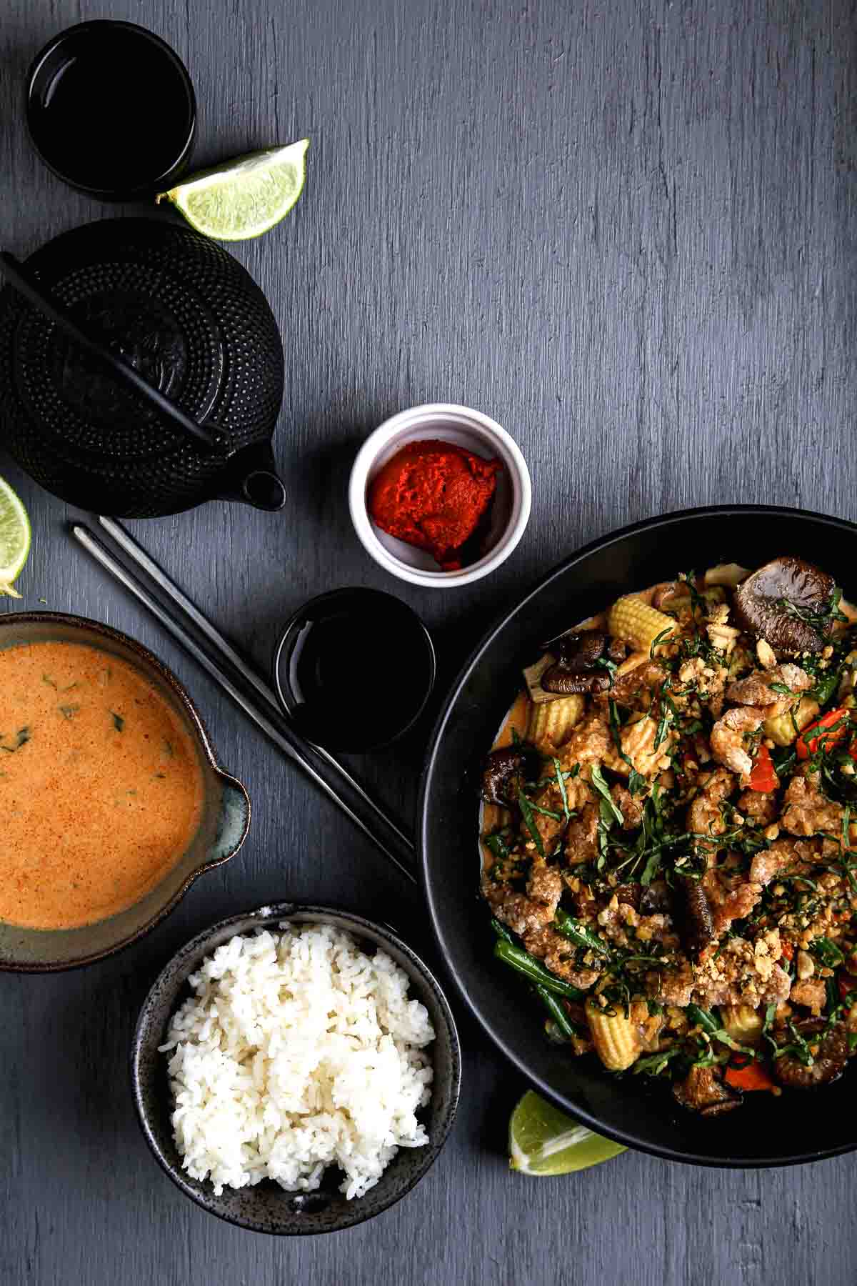 A serving suggestion for vegan red curry sauce with tofu, mushrooms, vegetables, and rice.
