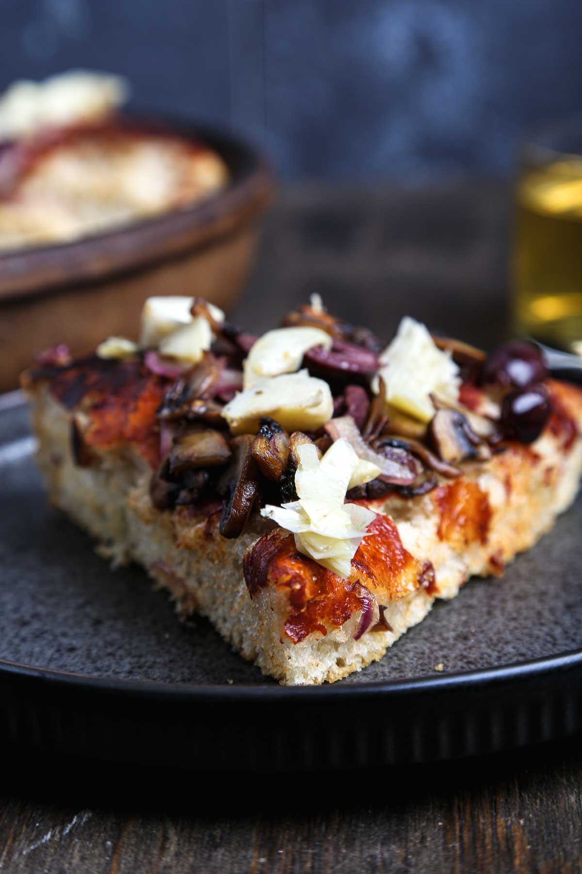 Close-up of pizza al padellino with crisp golden crust and vegetable toppings.