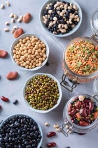 Dried beans and lentils in bowls and jars, pantry staples that store well and last a long time.